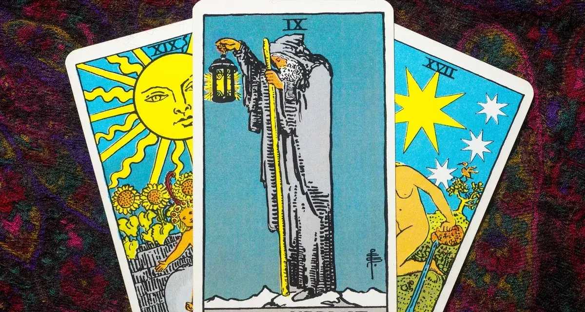 Tarot tak nie: karta Pustelnik w centrum, po bokach Słońce i Gwiazda.