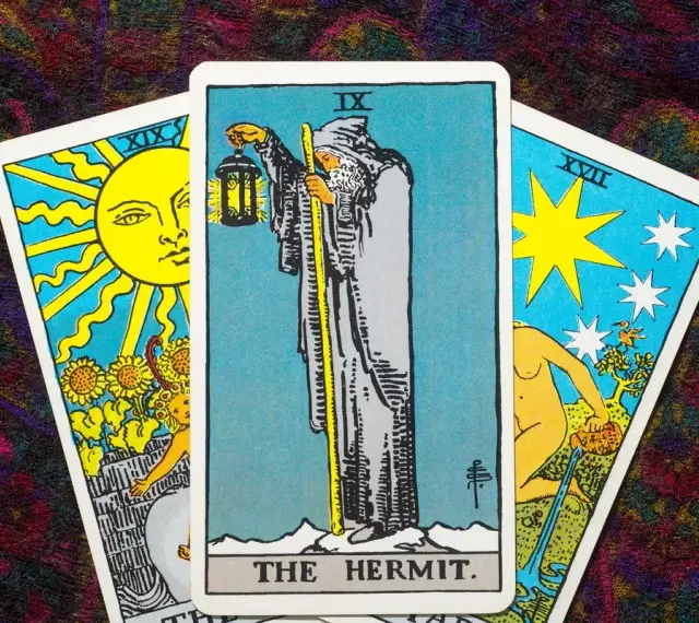 Tarot tak nie: karta Pustelnik w centrum, po bokach Słońce i Gwiazda.