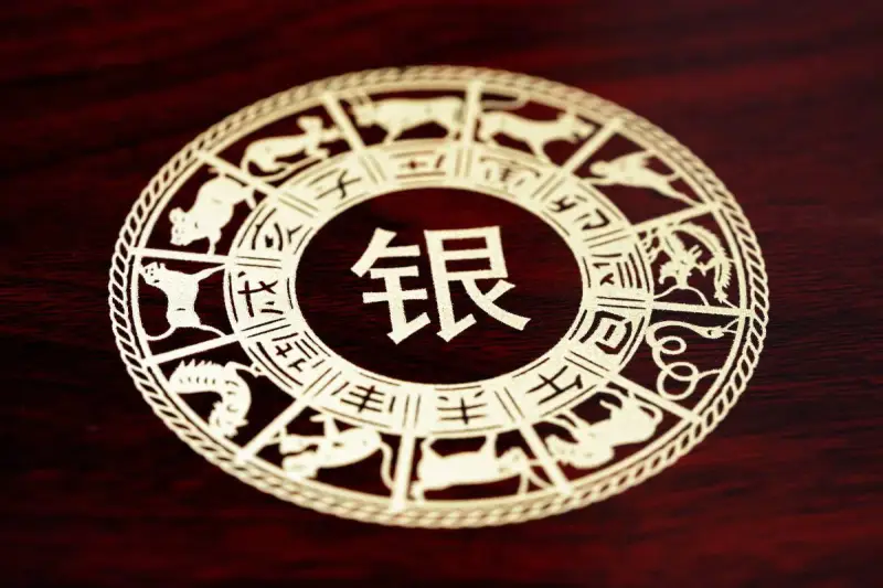 Ozdobny kalendarz chiński z motywami zwierząt zodiaku i chińskim znakiem "srebro".